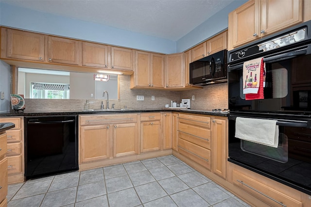 kitchen with light tile patterned flooring, decorative backsplash, a sink, and black appliances