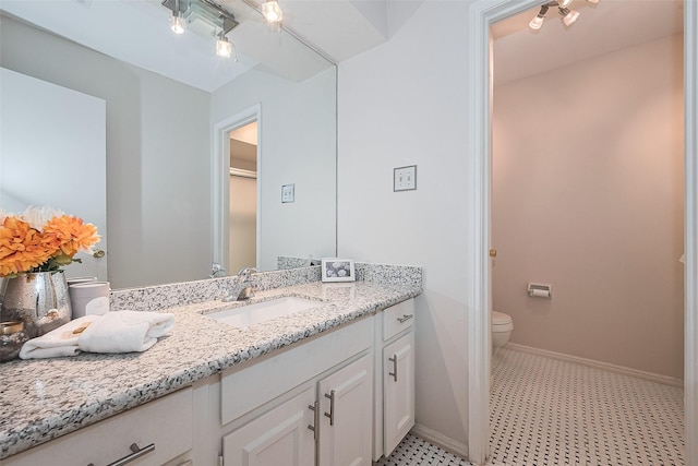 bathroom with baseboards, tile patterned floors, vanity, and toilet