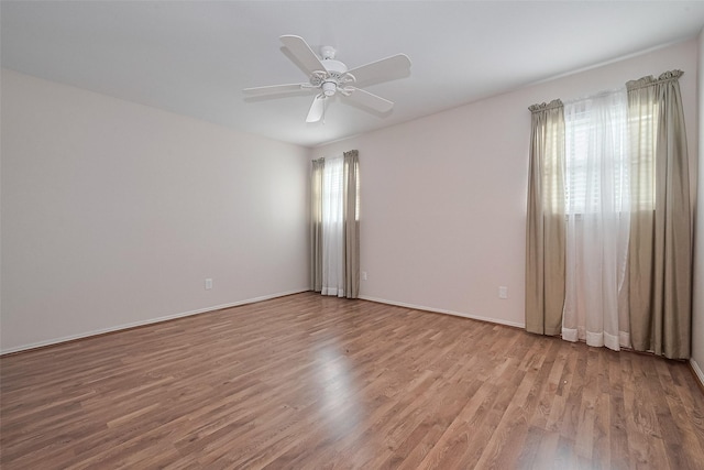 empty room featuring baseboards, ceiling fan, and wood finished floors