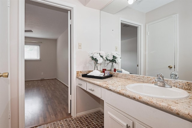bathroom with vanity, baseboards, and wood finished floors