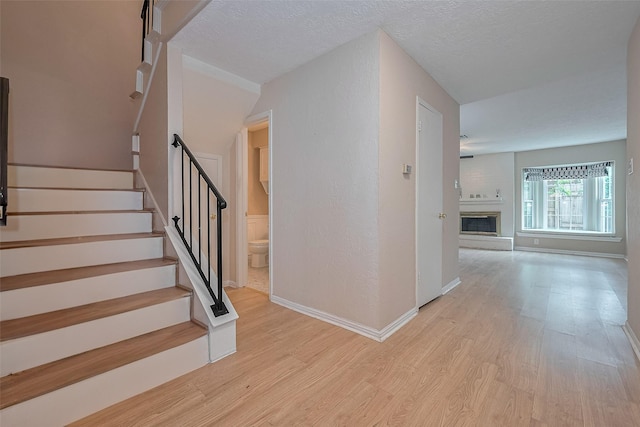 772 Thicket Ln, Houston, TX 77079 - stairs with baseboards, wood finished floors, and a fireplace