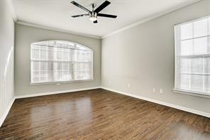 spare room featuring ceiling fan, baseboards, ornamental molding, and wood finished floors