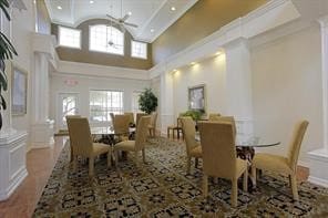 dining area with ornate columns, crown molding, a towering ceiling, and recessed lighting
