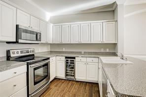 kitchen featuring white cabinets, beverage cooler, appliances with stainless steel finishes, and a sink