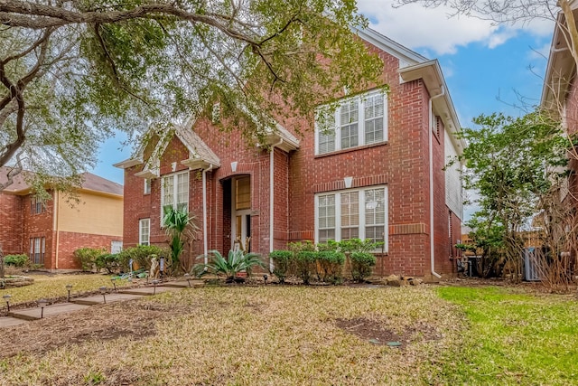 traditional-style house with a front lawn and brick siding