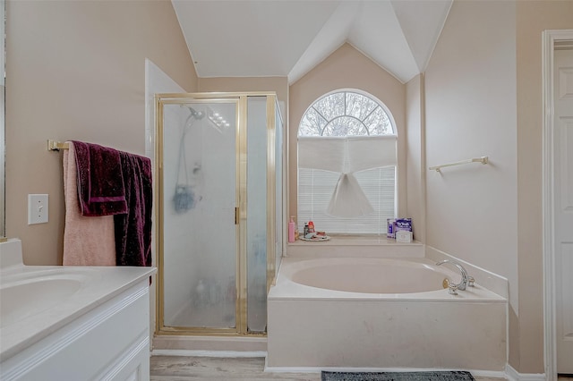 full bathroom with a shower stall, a garden tub, vaulted ceiling, and vanity