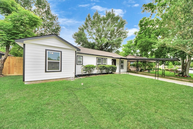 ranch-style home with fence, a carport, and a front lawn