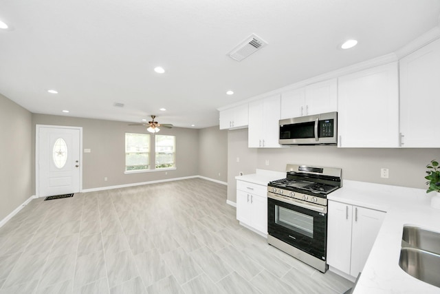 kitchen with white cabinets, appliances with stainless steel finishes, light countertops, baseboards, and visible vents