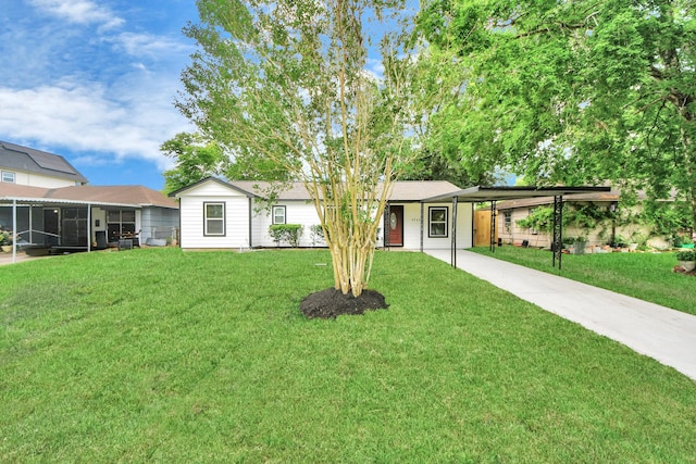 ranch-style home with an attached carport, concrete driveway, a sunroom, and a front lawn