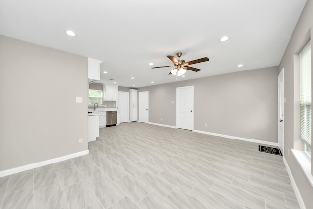 unfurnished living room featuring recessed lighting, a ceiling fan, baseboards, and a sink