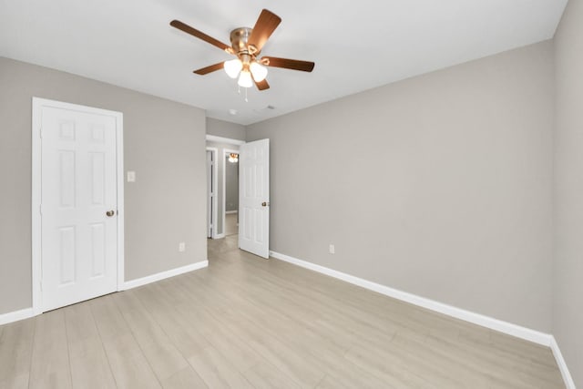 unfurnished bedroom featuring baseboards, visible vents, ceiling fan, and light wood-style floors