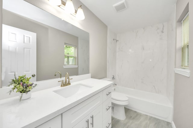 bathroom with vanity, bathtub / shower combination, toilet, and visible vents