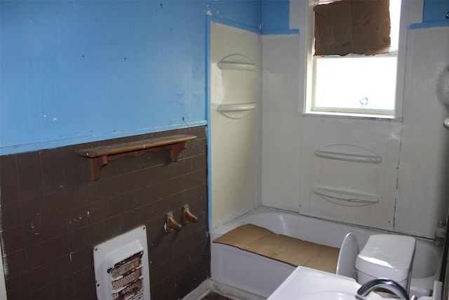 full bath with a shower, tile walls, wainscoting, and a bath