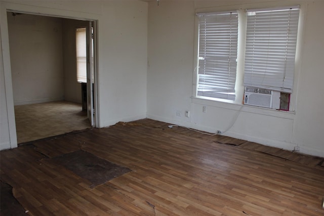 unfurnished room featuring baseboards, wood finished floors, and cooling unit