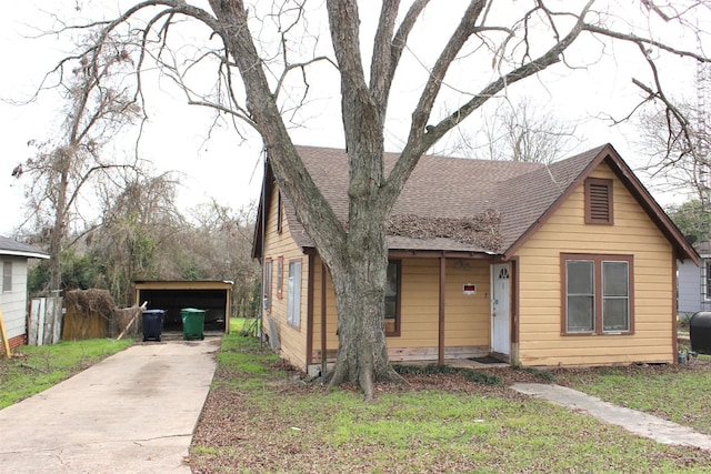 bungalow-style home featuring roof with shingles, heating fuel, concrete driveway, and a front lawn