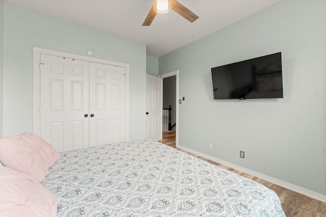 bedroom with baseboards, a ceiling fan, a closet, and wood finished floors
