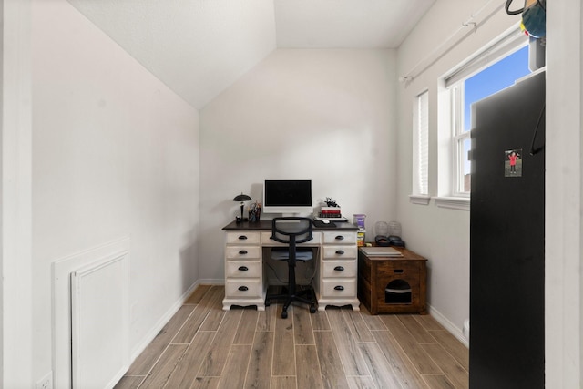 office featuring wood tiled floor, baseboards, and vaulted ceiling