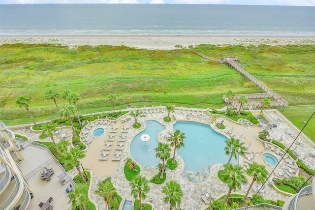 drone / aerial view featuring a beach view and a water view