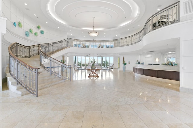 interior space with recessed lighting, a tray ceiling, stairway, and a towering ceiling