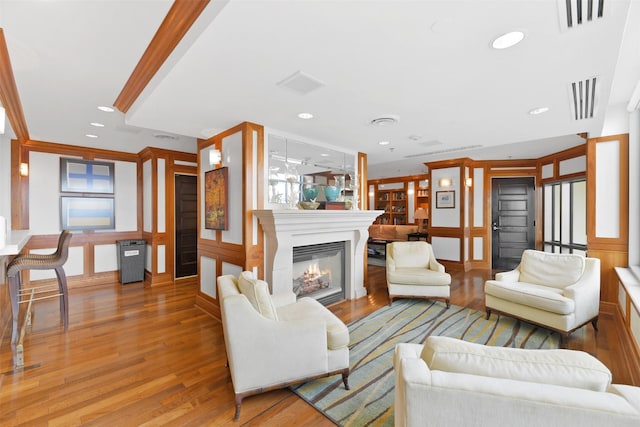living room featuring visible vents, recessed lighting, light wood-style flooring, and a glass covered fireplace