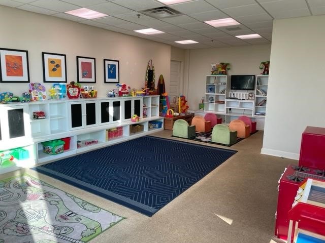 playroom featuring carpet flooring and a drop ceiling