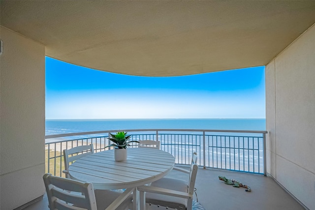 balcony featuring a water view and outdoor dining space