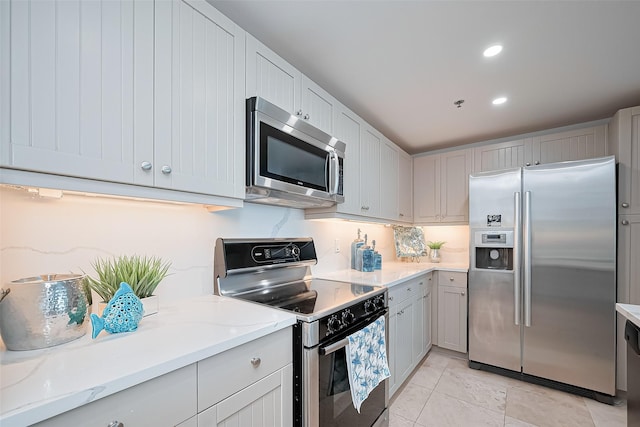 kitchen featuring recessed lighting, appliances with stainless steel finishes, and light stone counters