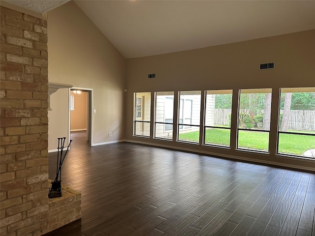 unfurnished living room with high vaulted ceiling, visible vents, dark wood-style floors, and baseboards