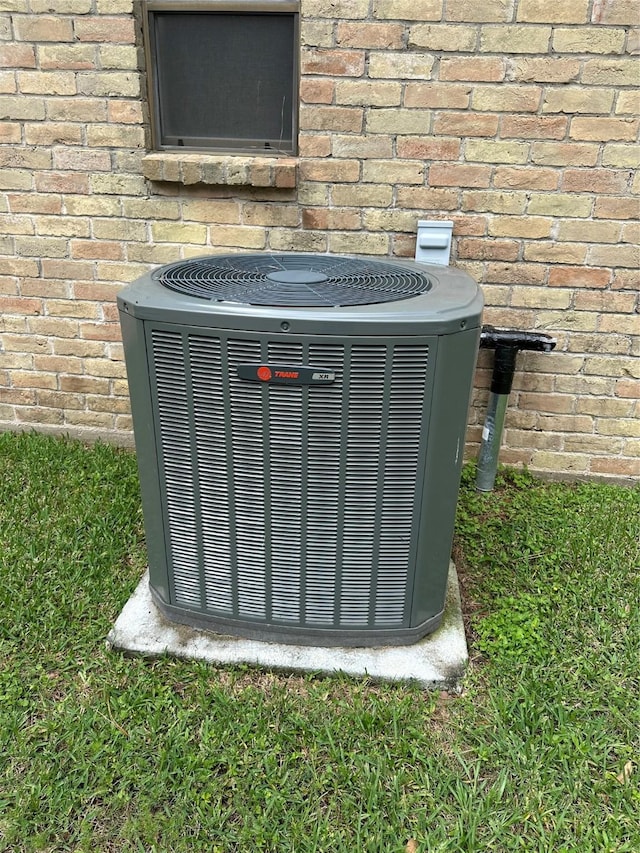 details featuring cooling unit and brick siding