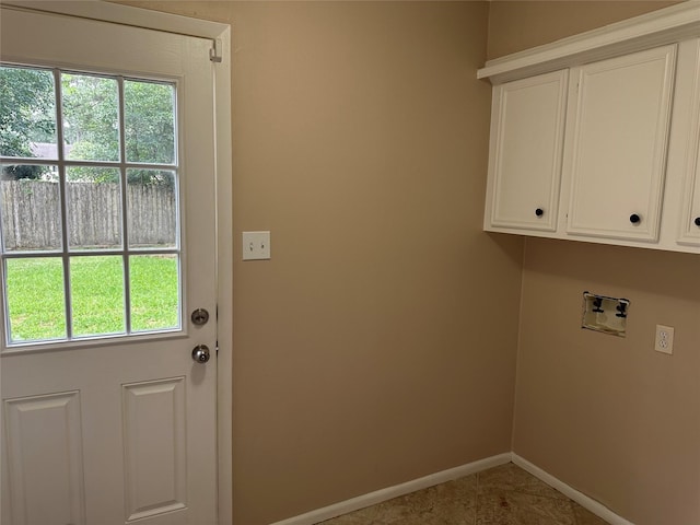 laundry room featuring washer hookup, baseboards, tile patterned flooring, and cabinet space