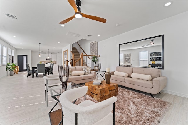 living room with a ceiling fan, baseboards, recessed lighting, visible vents, and stairway