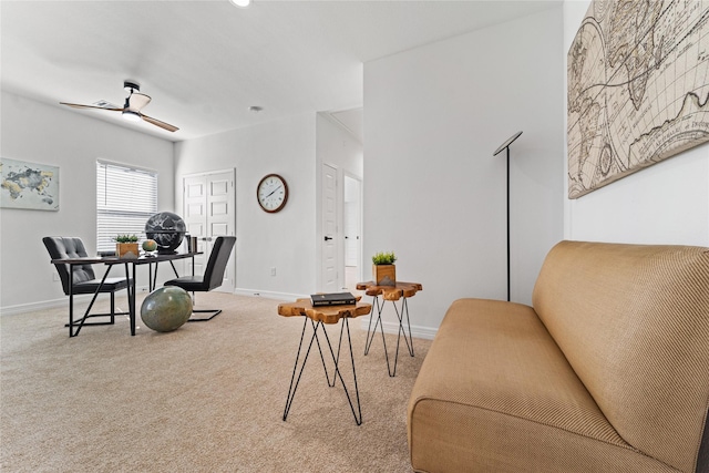 carpeted living area with baseboards and a ceiling fan