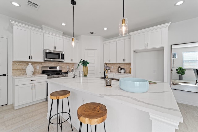 kitchen featuring visible vents, tasteful backsplash, stainless steel appliances, recessed lighting, and white cabinetry