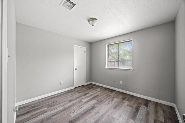 8803 Enchanted Forest Dr, Houston, TX 77088 - spare room with baseboards, a textured ceiling, wood finished floors, and visible vents