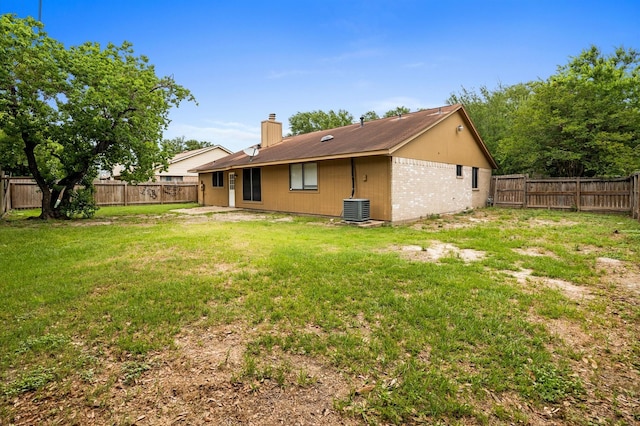 8803 Enchanted Forest Dr, Houston, TX 77088 - back of property featuring a fenced backyard, a yard, a chimney, and central AC unit