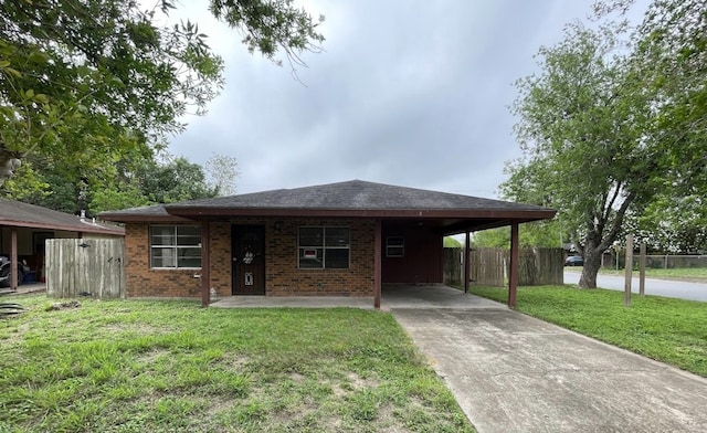 ranch-style home featuring a carport, brick siding, fence, a front lawn, and concrete driveway