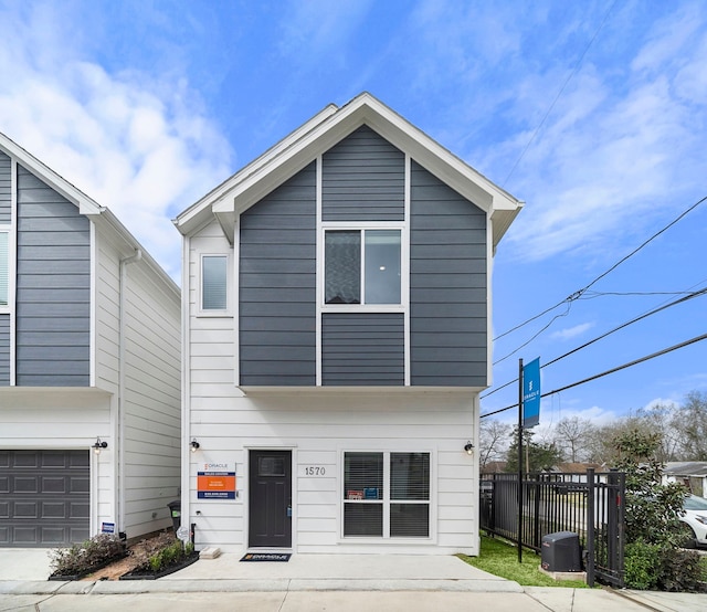 modern home featuring fence and a garage