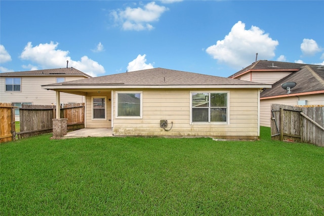 rear view of property with a yard, a patio, a shingled roof, and a fenced backyard