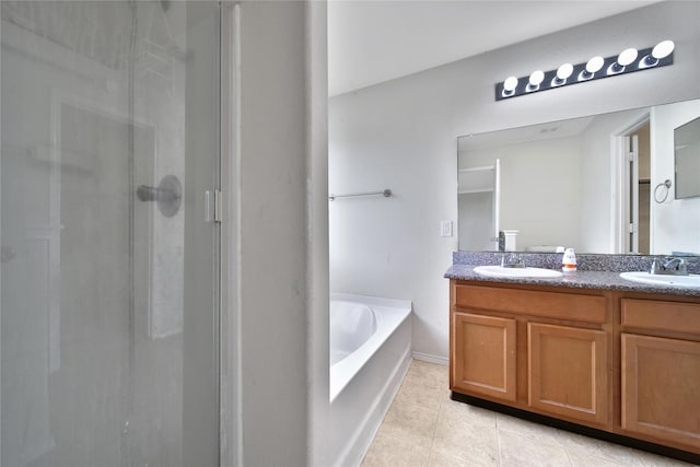 bathroom featuring a sink, tile patterned floors, a shower stall, and a garden tub