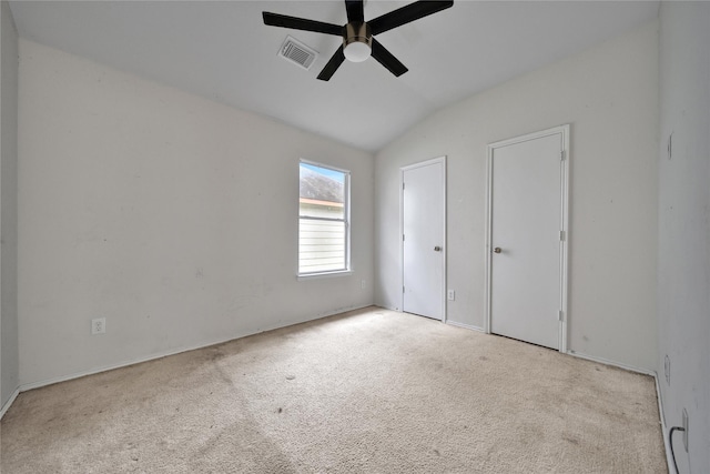 unfurnished bedroom with visible vents, carpet flooring, multiple closets, and lofted ceiling