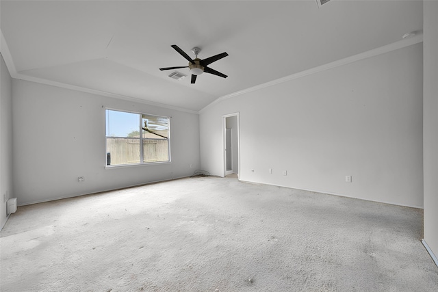 empty room with crown molding, visible vents, carpet flooring, a ceiling fan, and vaulted ceiling