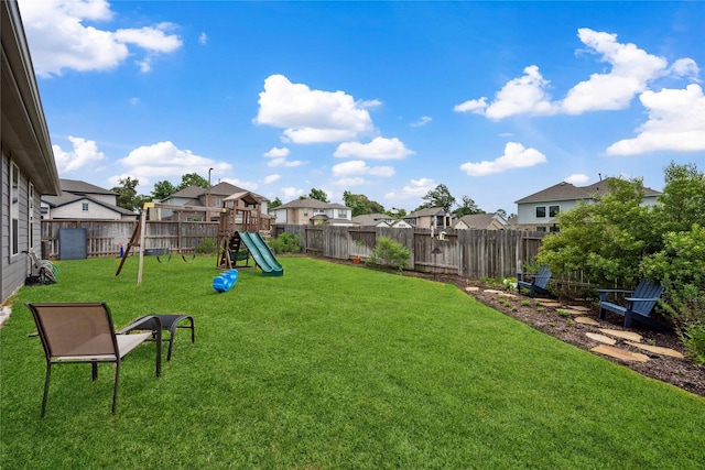 view of yard featuring a residential view, a fenced backyard, and a playground