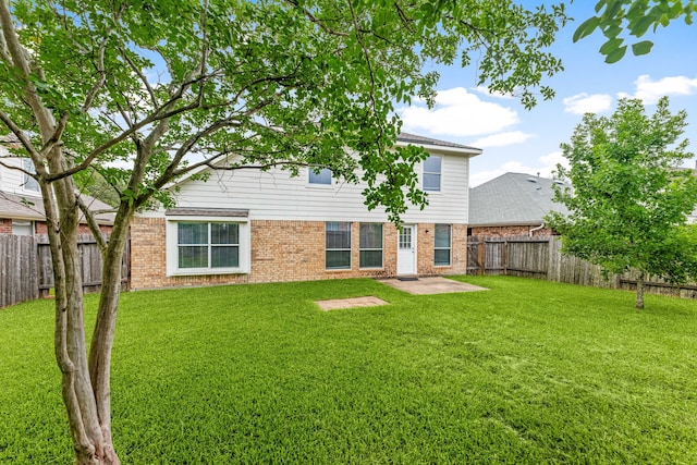1811 Salt Valley Dr, Katy, TX 77493 - back of house featuring a lawn, brick siding, a fenced backyard, and a patio area