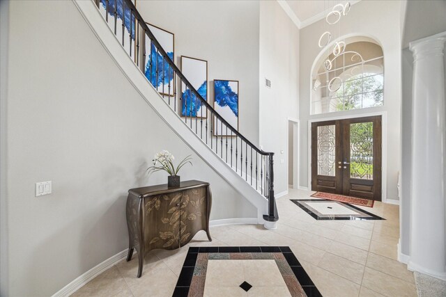 foyer entrance with an inviting chandelier, baseboards, a high ceiling, and stairway