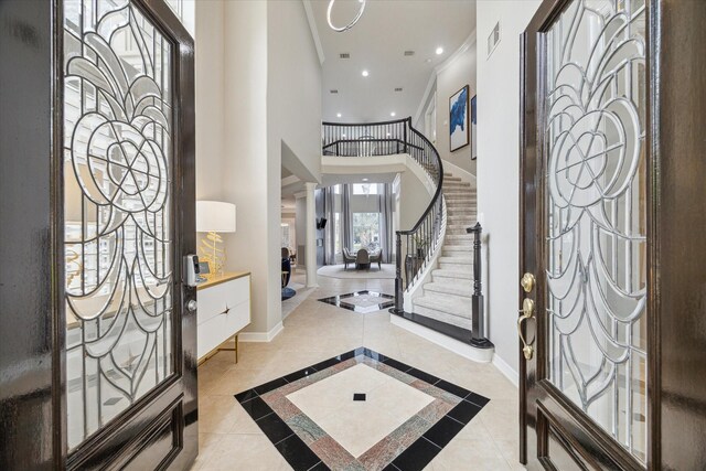 entrance foyer with a towering ceiling, visible vents, stairway, baseboards, and recessed lighting