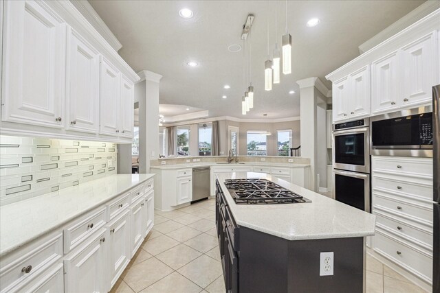 kitchen featuring a center island, recessed lighting, white cabinets, backsplash, and stainless steel appliances