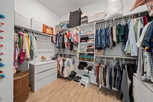 walk in closet with light wood-style floors