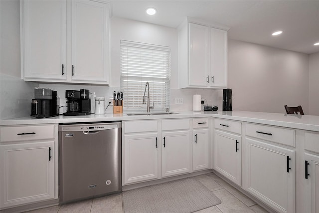 kitchen featuring stainless steel dishwasher, light countertops, white cabinetry, a sink, and light tile patterned floors