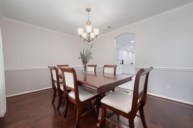 dining room featuring arched walkways, a chandelier, baseboards, wood finished floors, and ornamental molding