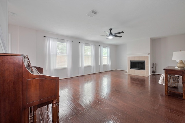 unfurnished living room with plenty of natural light, a fireplace, a ceiling fan, and visible vents
